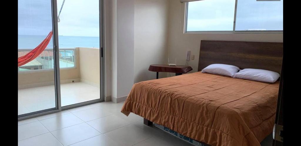 a bedroom with a bed with a view of the ocean at Departamento Familiar in Salinas