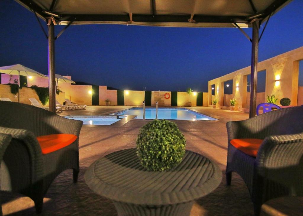 a patio with a table and chairs and a pool at Alma Private Villa in Jerash