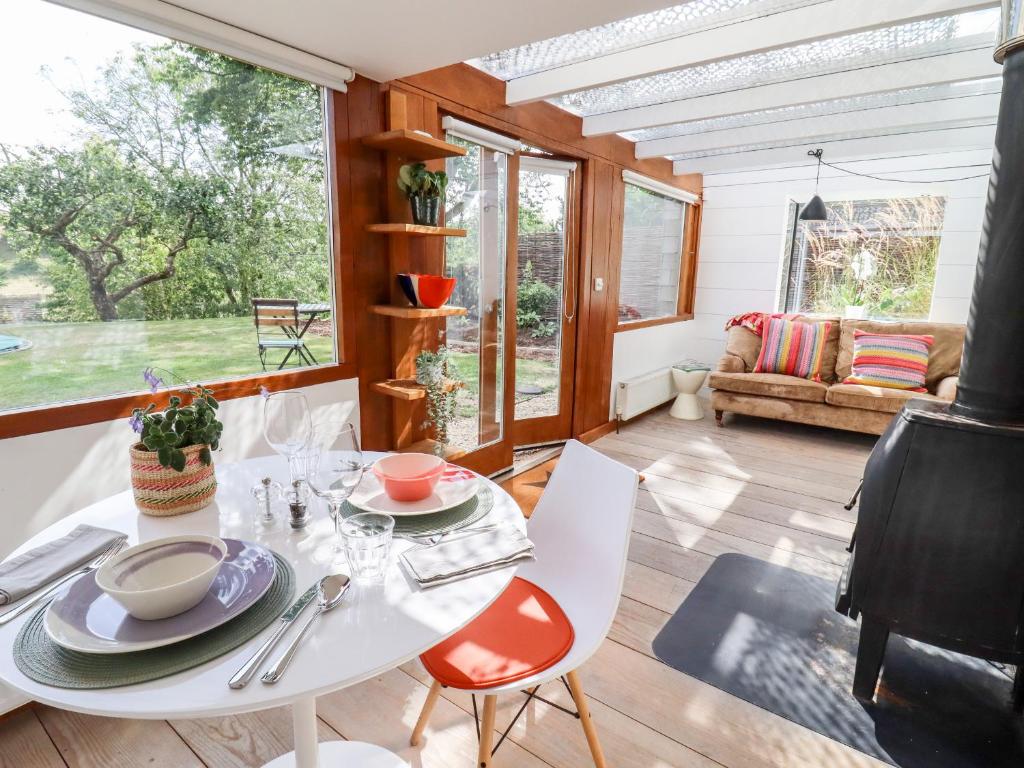 comedor con mesa blanca y sillas en Apple Cottage en Cheltenham