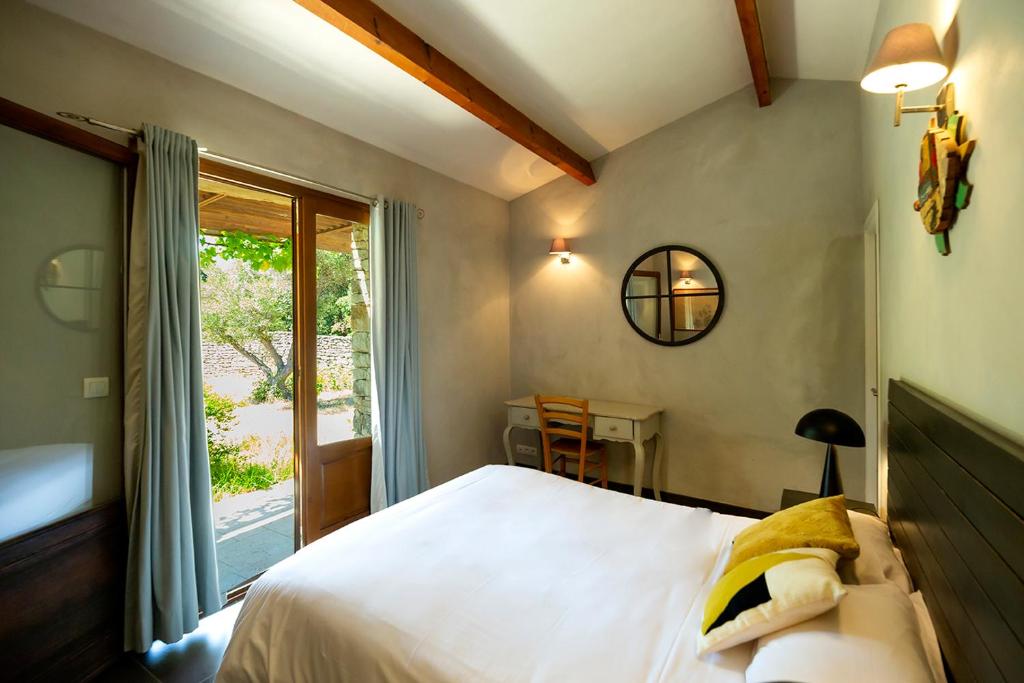 a bedroom with a bed and a table and a window at Les chambres SoleLuna Bonifacio in Bonifacio