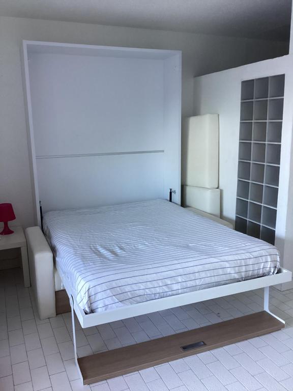 1 dormitorio con 1 cama blanca en una habitación en Le serpent de mer, en Le Grau-du-Roi