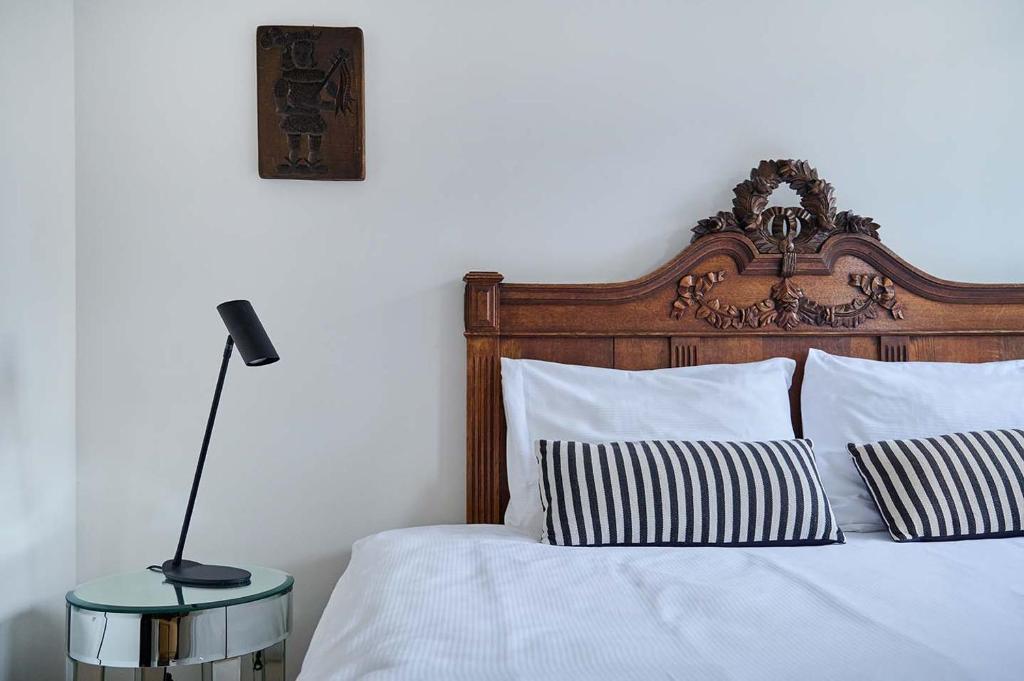 a bedroom with a bed with white sheets and a lamp at Hello I'm Local - Boutique Hostel in Haarlem