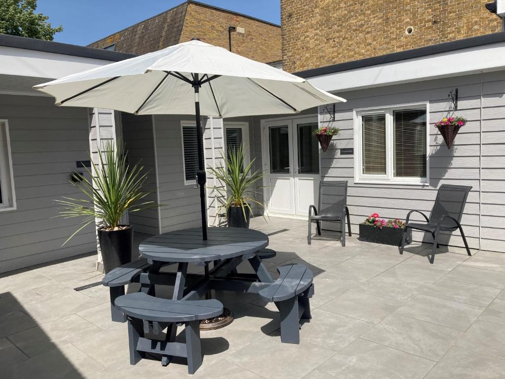 a table and chairs with an umbrella on a patio at Gresham in Kent
