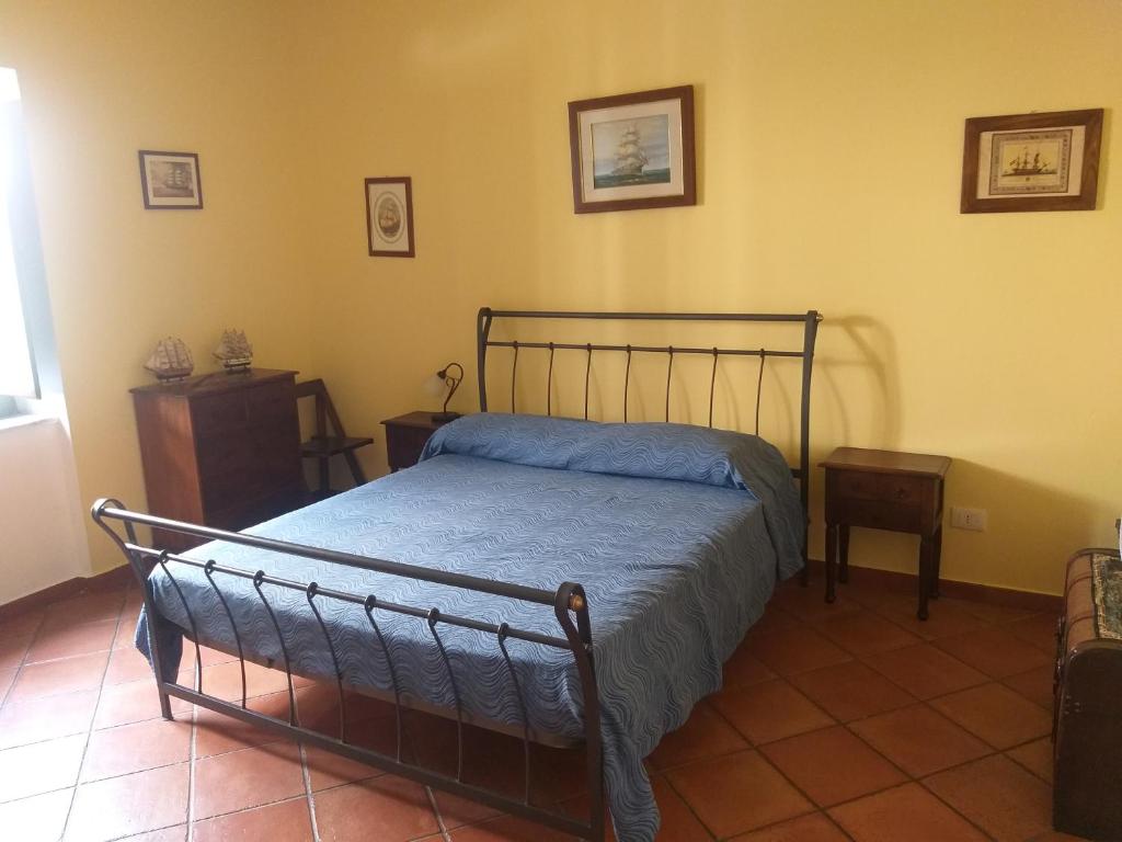 a bedroom with a bed with a blue comforter at La Dimora Del Nonno Marinaio in San Nicola Arcella