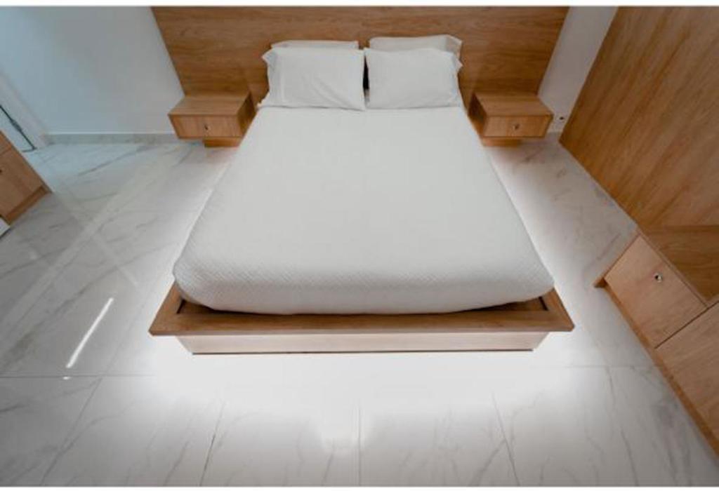 een wit bed op een houten platform in een kamer bij Luxury Studio in the heart of Kolonaki in Athene