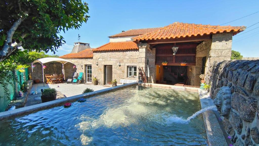 a house with a swimming pool in front of a house at São Braz Terrace in Landim