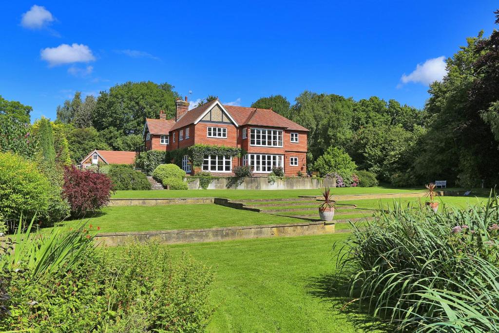a large red brick house with a green yard at Wellbrook Place by Group Retreats in Heathfield
