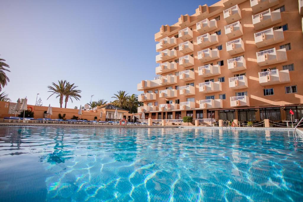 a large swimming pool in front of a hotel at Servatur Caribe in Playa de las Americas