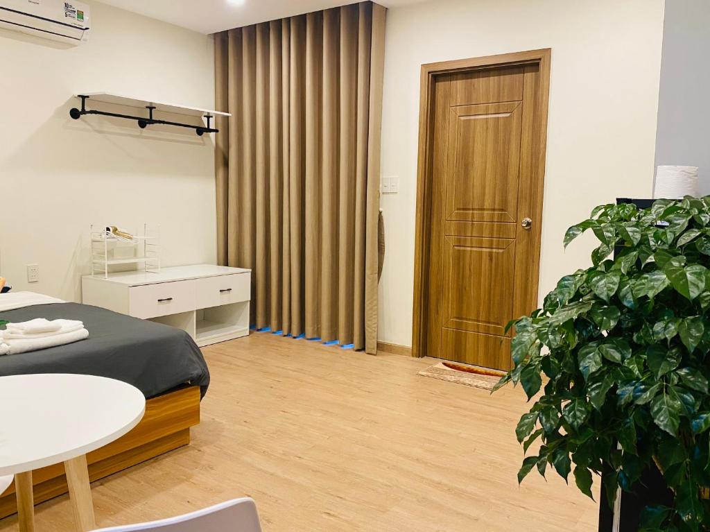 a bedroom with a bed and a table and a plant at B786 Airport Apartment in Ho Chi Minh City