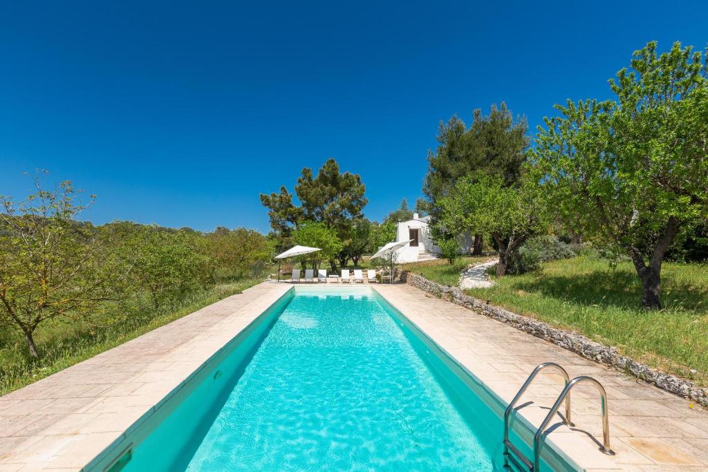une piscine extérieure avec une villa en arrière-plan dans l'établissement Villa Sessana by Perle di Puglia, à Ceglie Messapica
