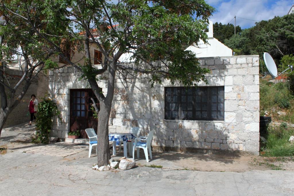 a house with a table and chairs in front of it at Seaside holiday house Milna, Hvar - 114 in Hvar