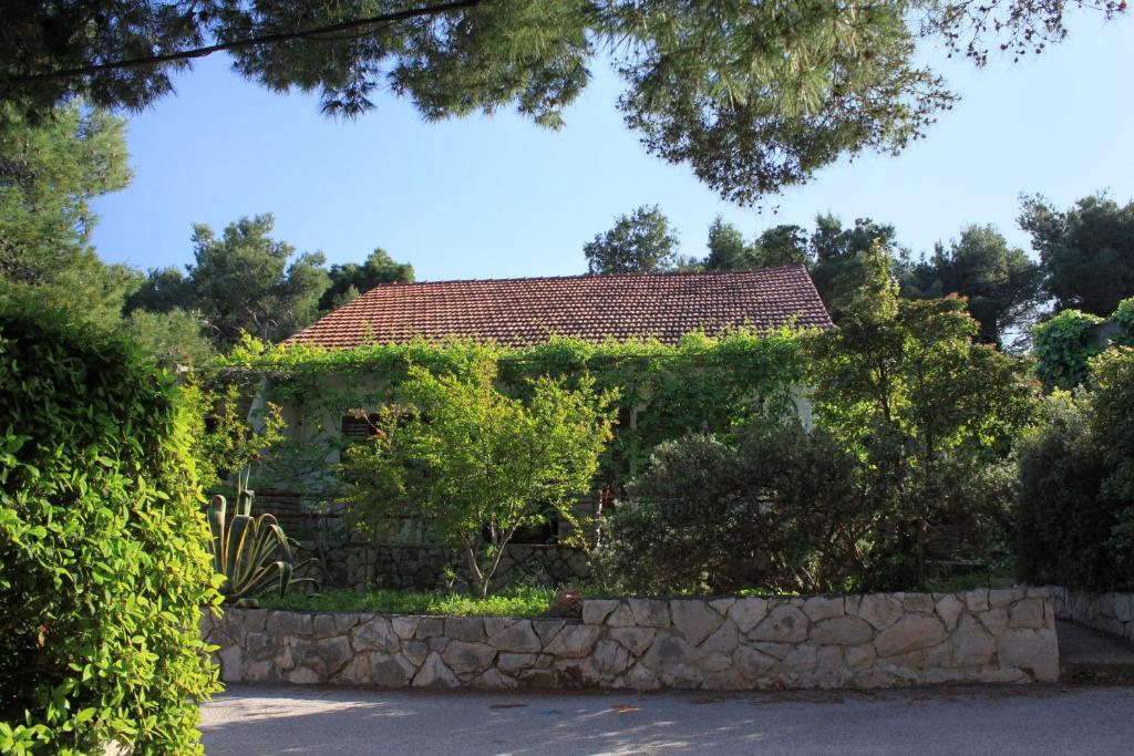 une maison avec une clôture en pierre devant elle dans l'établissement Apartments by the sea Mudri Dolac, Hvar - 118, à Vrboska