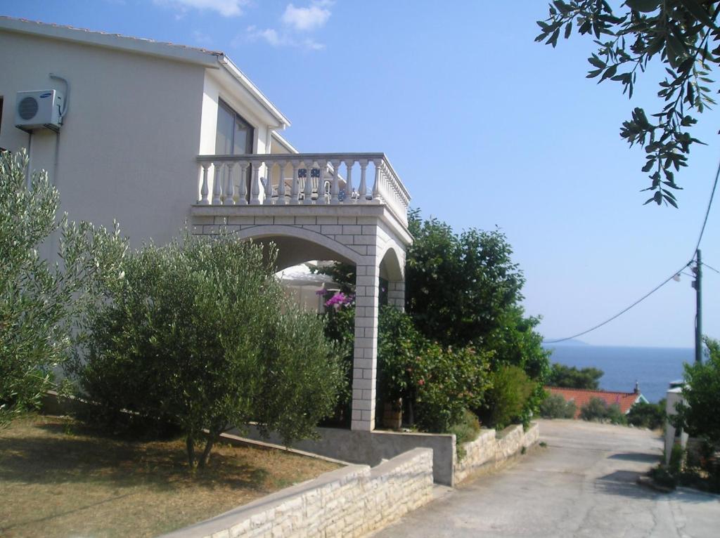 Cette maison blanche dispose d'un balcon sur le côté. dans l'établissement Apartments by the sea Prizba, Korcula - 149, à Prižba