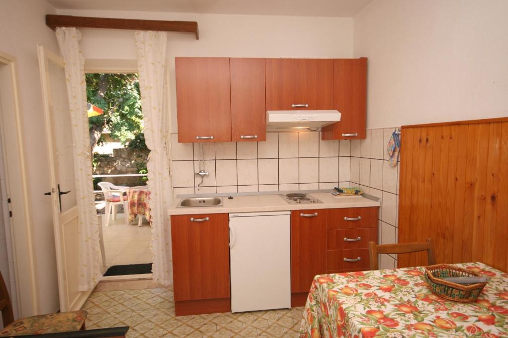 una cucina con armadi in legno e tavolo con tavolo di Apartments and rooms by the sea Hvar - 141 a Hvar