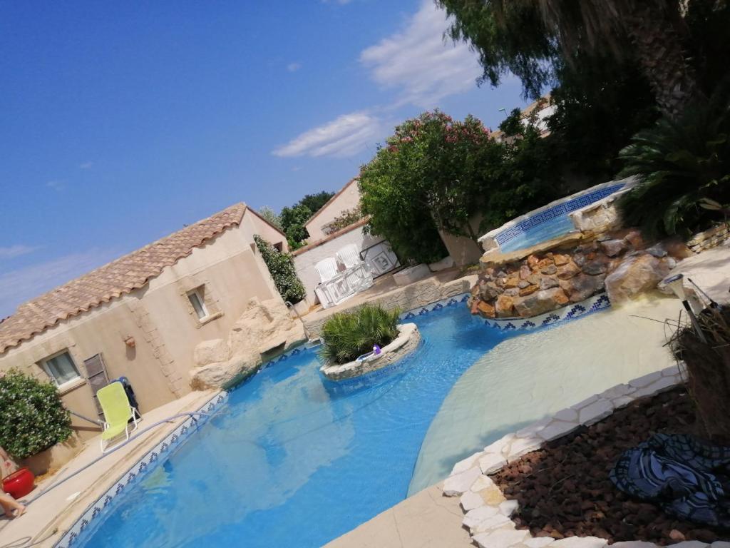 an image of a swimming pool at a resort at Maisonnette piscine en été clim in Pia