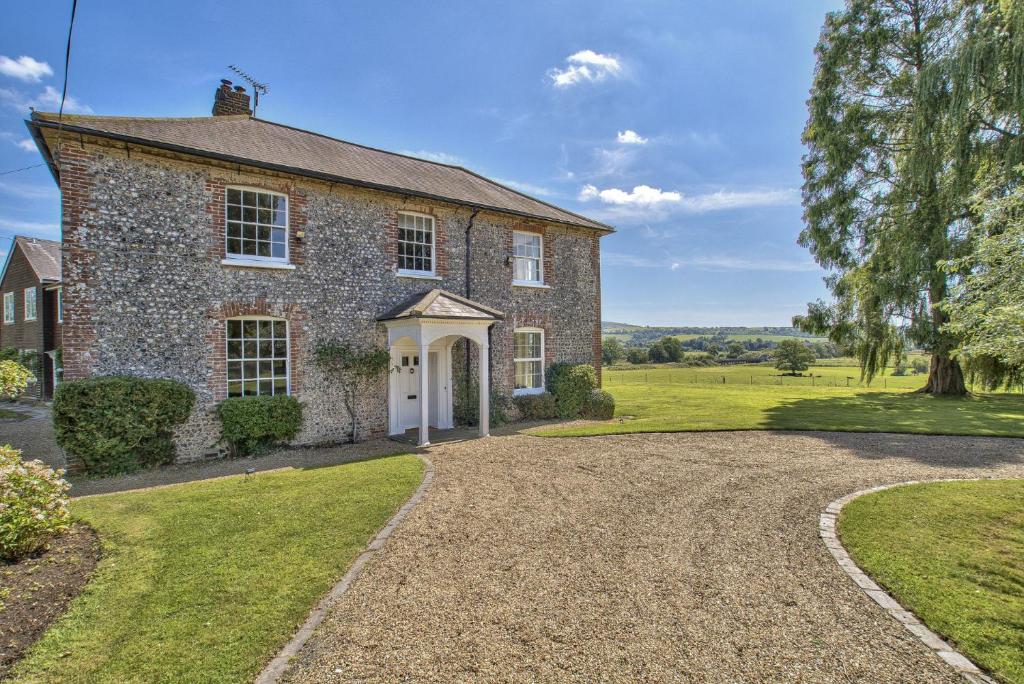 ein altes Backsteinhaus mit Kieseinfahrt in der Unterkunft Timberley Farm by Group Retreats in Pulborough