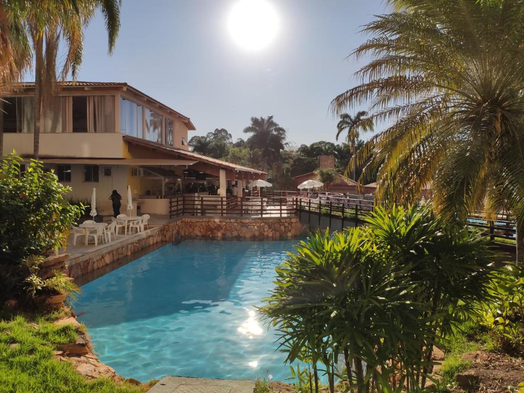 a large swimming pool in front of a house at Suíte Hot Springs B3 Hotéis Hospedagem - Até 4 adultos in Caldas Novas