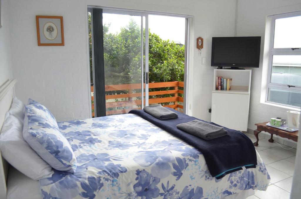 a bedroom with a bed and a large window at 24 on Karee in Stilbaai