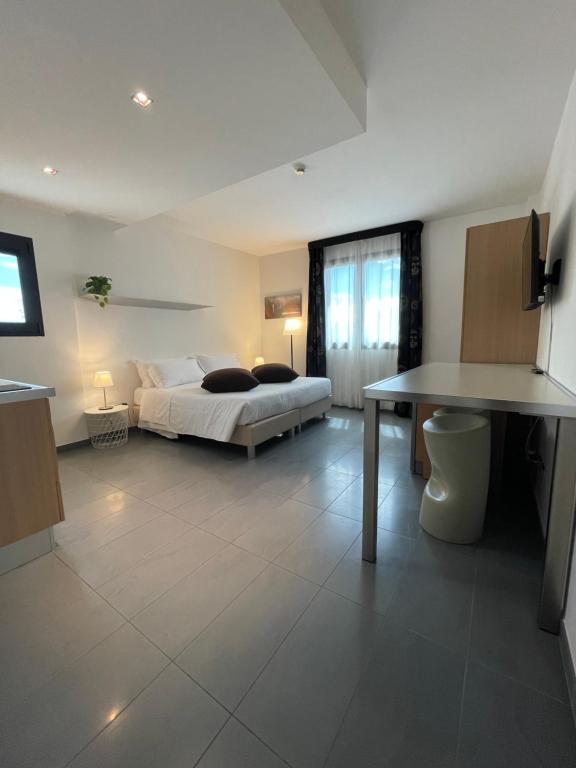 Matrix Hotel & Residence في فيغونزا: غرفة نوم فيها سرير وطاولة فيها