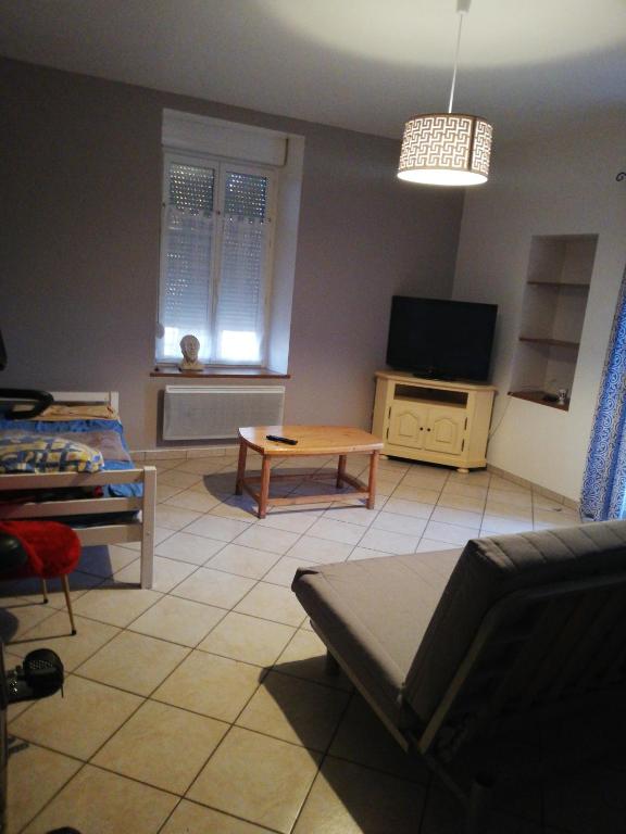 ein Wohnzimmer mit einem Sofa und einem TV in der Unterkunft Appartement 5 couchages 35mn du Luxembourg in Spincourt