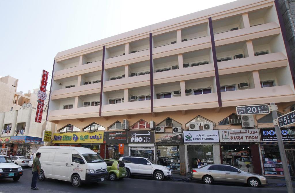 un gran edificio con coches estacionados frente a él en Zaineast Hotel en Dubái