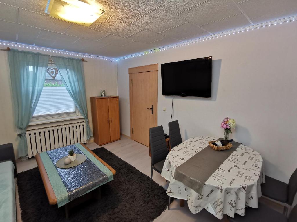 ein Wohnzimmer mit einem Tisch und einem Flachbild-TV in der Unterkunft Fewo Krysik Unterdeck in Lühmannsdorf