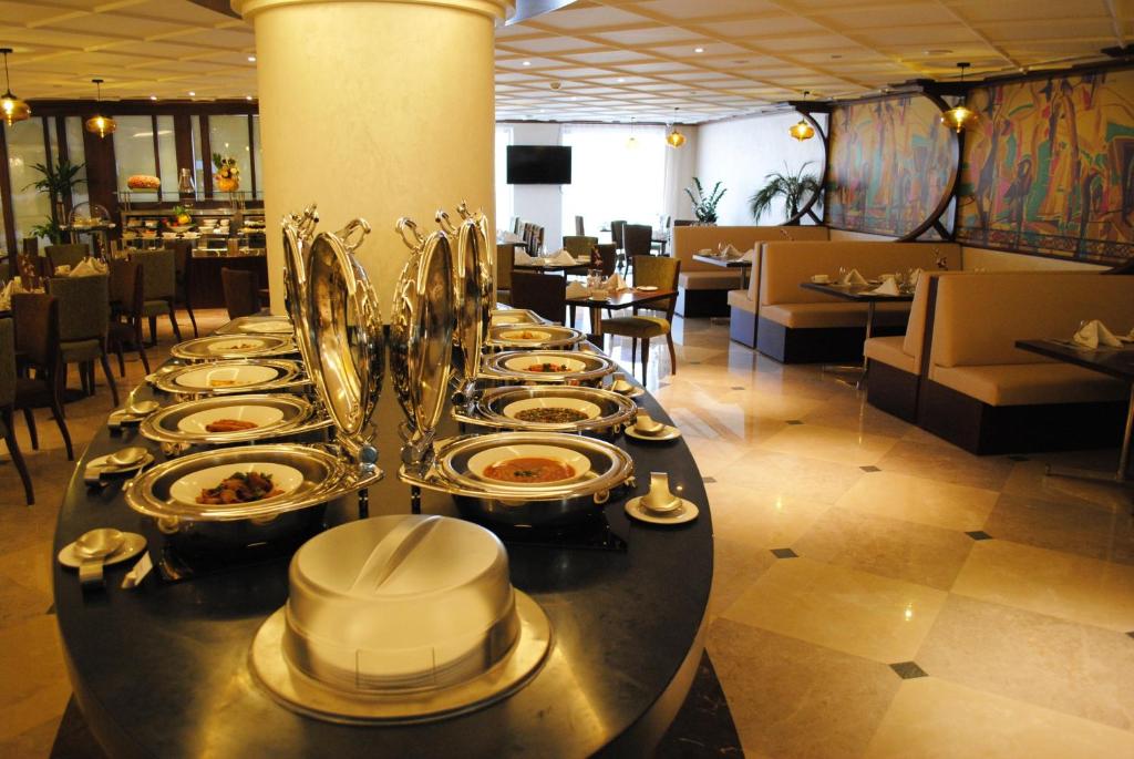 a buffet line with plates of food in a restaurant at Raviz Center Point Hotel in Dubai