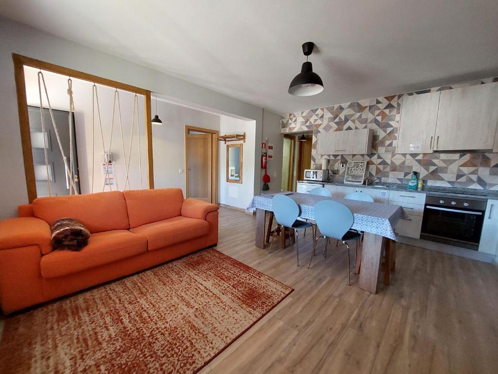 un soggiorno con divano arancione e una cucina di Casa do Pátio a Sabugueiro