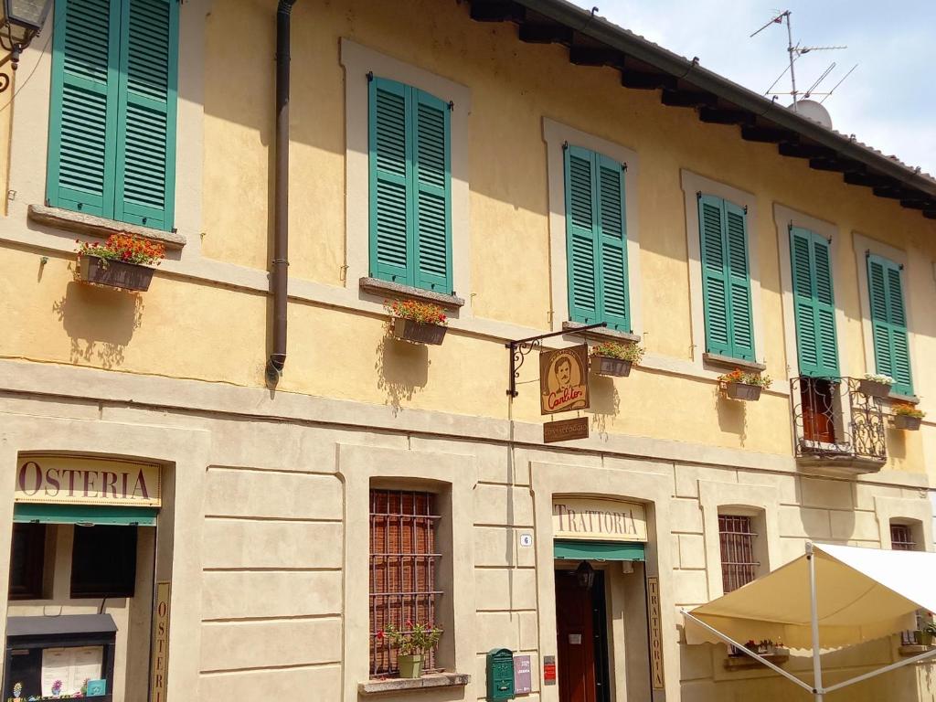 budynek z zielonymi okiennicami na boku w obiekcie Carlito's Trattoria con alloggio w mieście Vertemate