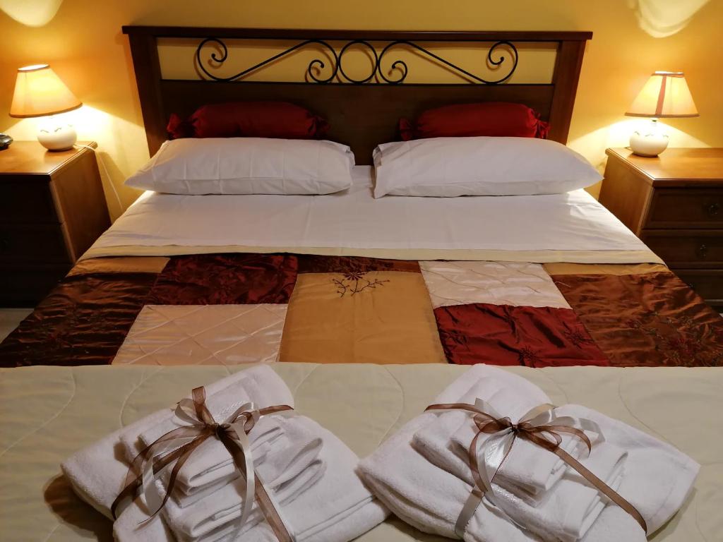 a bed with white towels and bows on it at Anima d'Orcia - Ampio appartamento in pieno centro storico! in San Quirico dʼOrcia