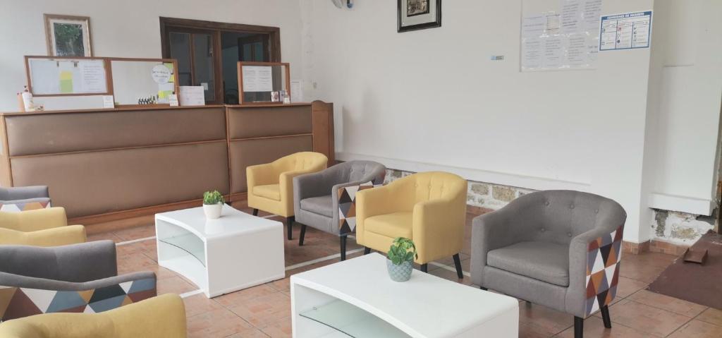 a waiting room with yellow and gray chairs and tables at Veronique Christine in Libreville