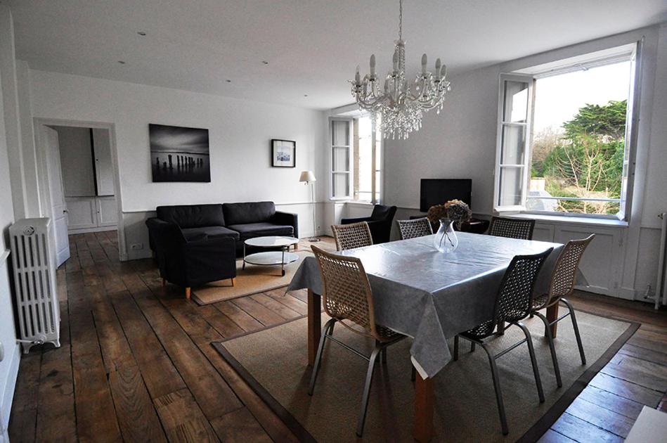 une salle à manger et un salon avec une table et des chaises dans l'établissement Saint Malo Solidor vue mer BRECEL 1, à Saint-Malo