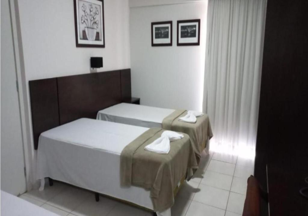 duas camas num quarto de hotel com toalhas em Flat em Frente a USP - Centrinho - CPO - Medicina em Bauru