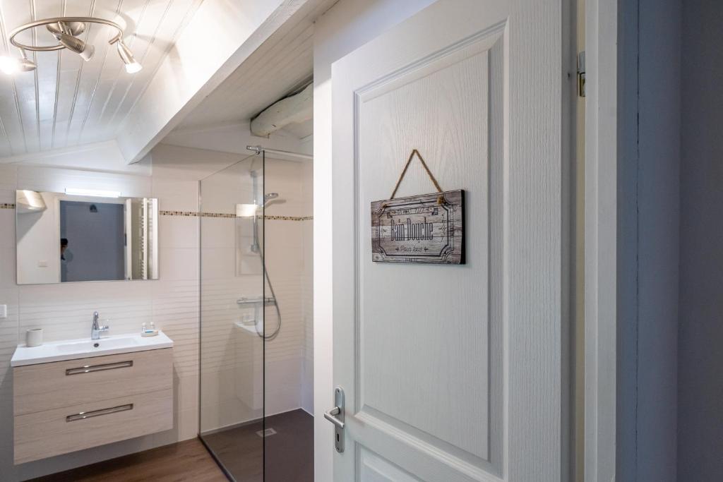 uma casa de banho com um chuveiro e uma porta branca em Domaine Des Coutelleries em Sallertaine
