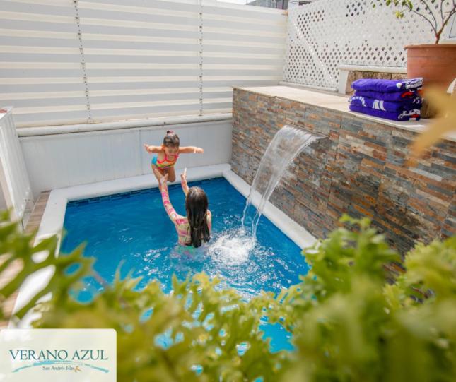 duas raparigas a brincar numa piscina com uma fonte em Alojamiento Turístico Verano Azul San Andrés em San Andrés