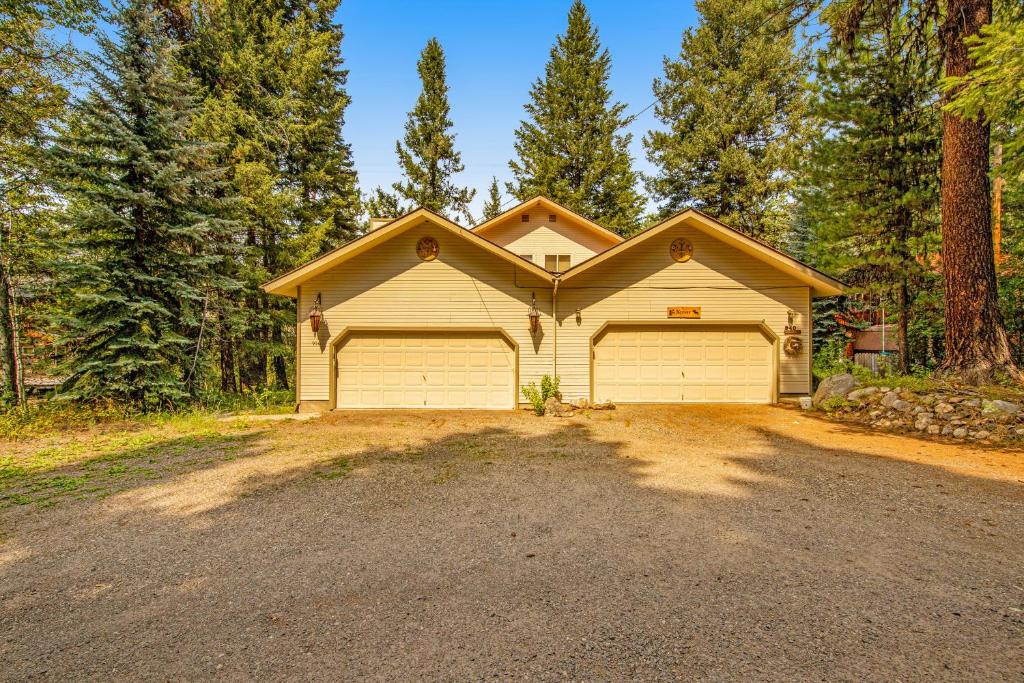 a house with a garage in the woods at Retreat in McCall