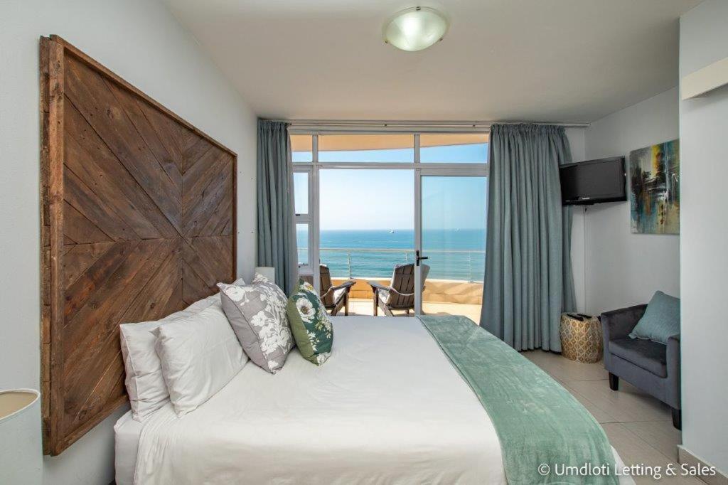 - une chambre avec un lit et une vue sur l'océan dans l'établissement Sugar Crest 3B with inverter, à Umdloti