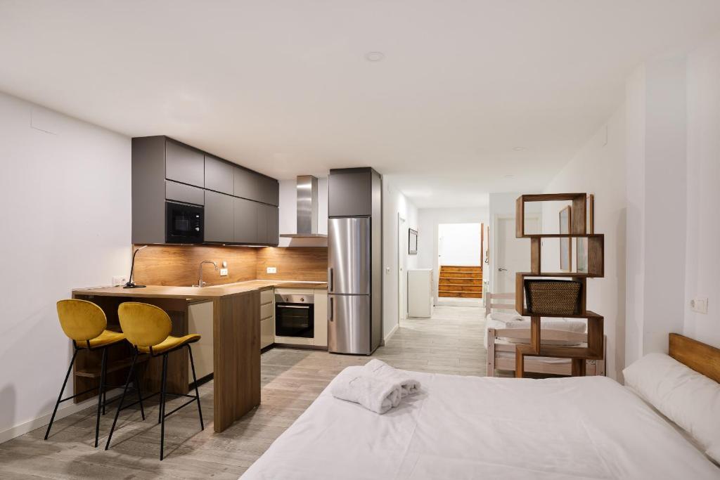 a bedroom with a bed and a kitchen with a counter at TuApartamento Navarreria Loft in Pamplona