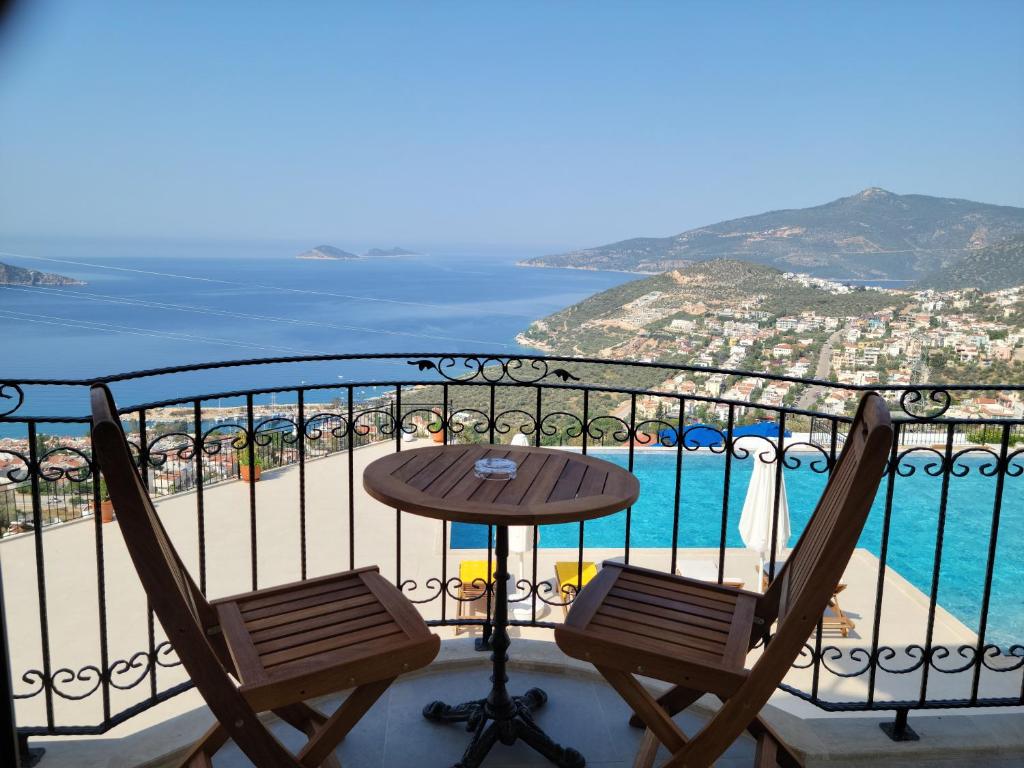 een tafel en stoelen op een balkon met uitzicht op de oceaan bij The Mediteran Hotel in Kalkan