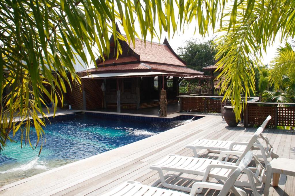 a swimming pool with chairs and a gazebo at Inrawadee Resort in Jomtien Beach