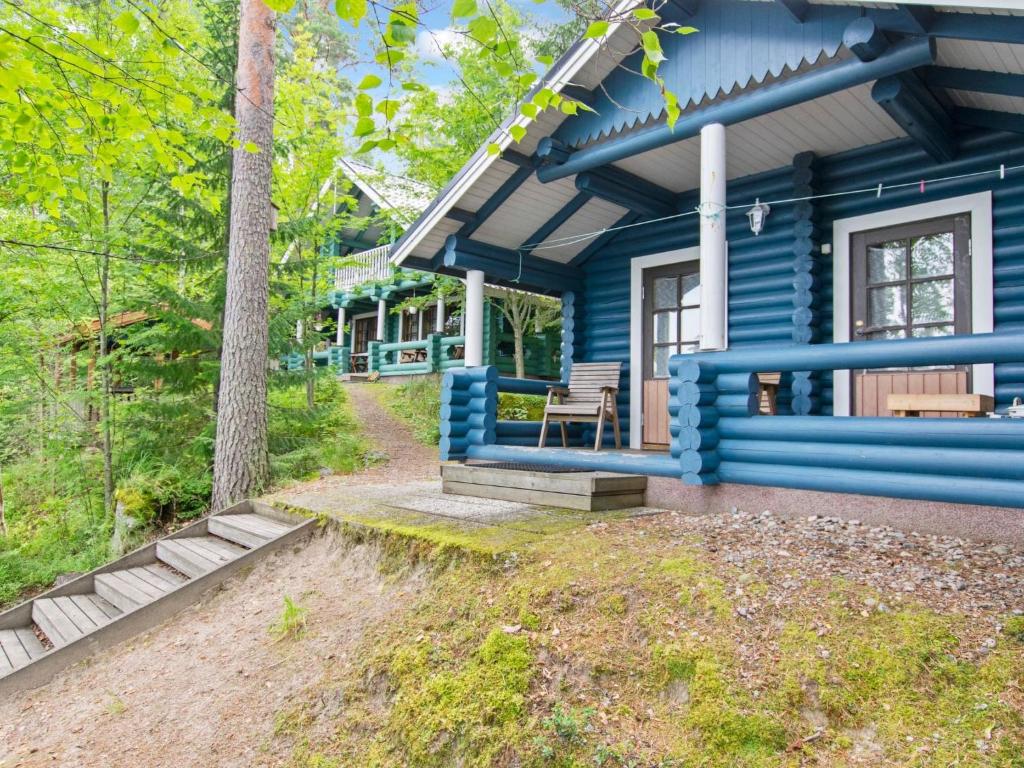 een blauw huis met een bankje ervoor bij Holiday Home Kalliorinne by Interhome in Pyhäjärvi
