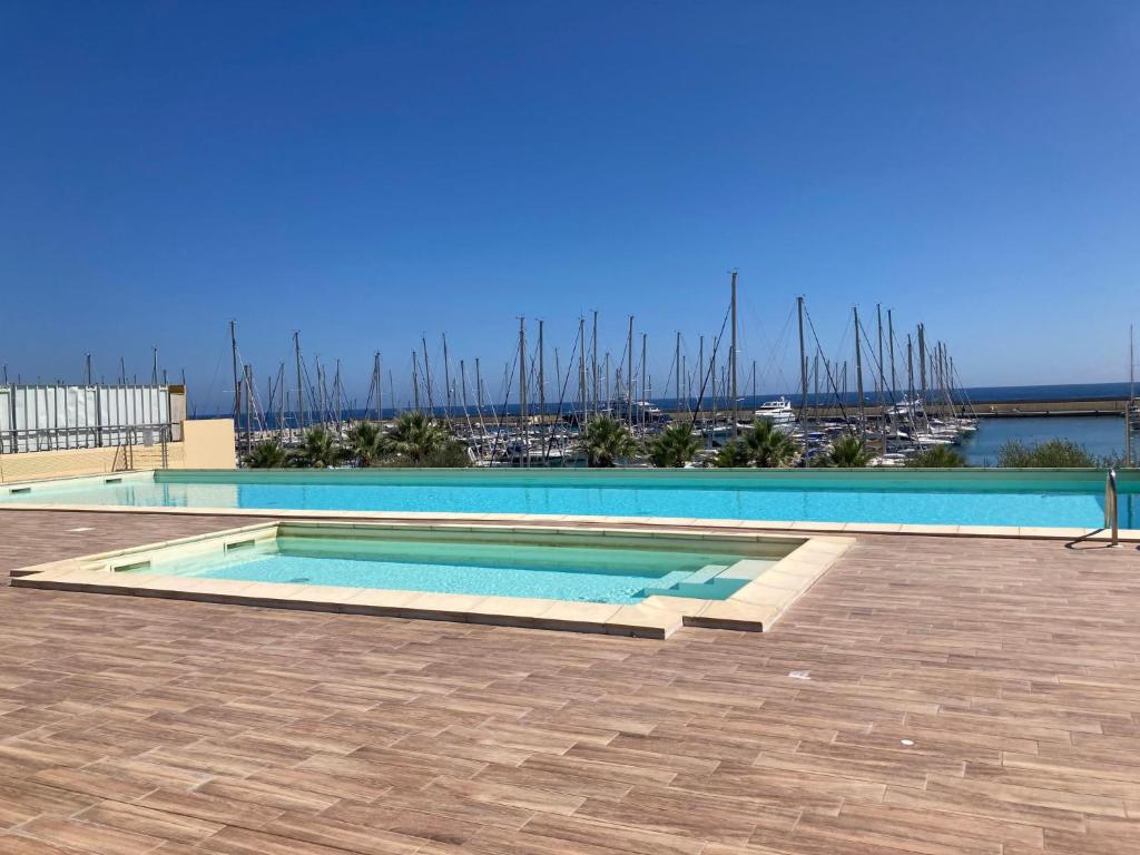 a swimming pool with a view of a marina at Apartment Marta by Interhome in Terzorio
