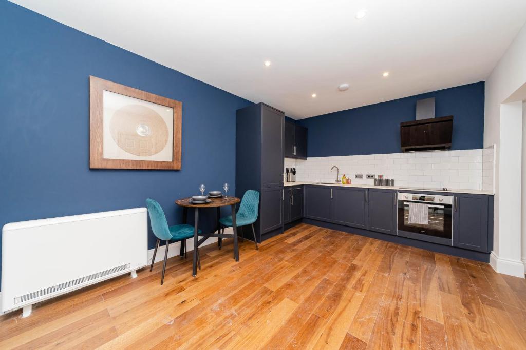 uma cozinha com paredes azuis e uma mesa e cadeiras em Morden 2 Bedroom flat Central Brighton Location Sleep 6 guests I G44CL em Brighton & Hove