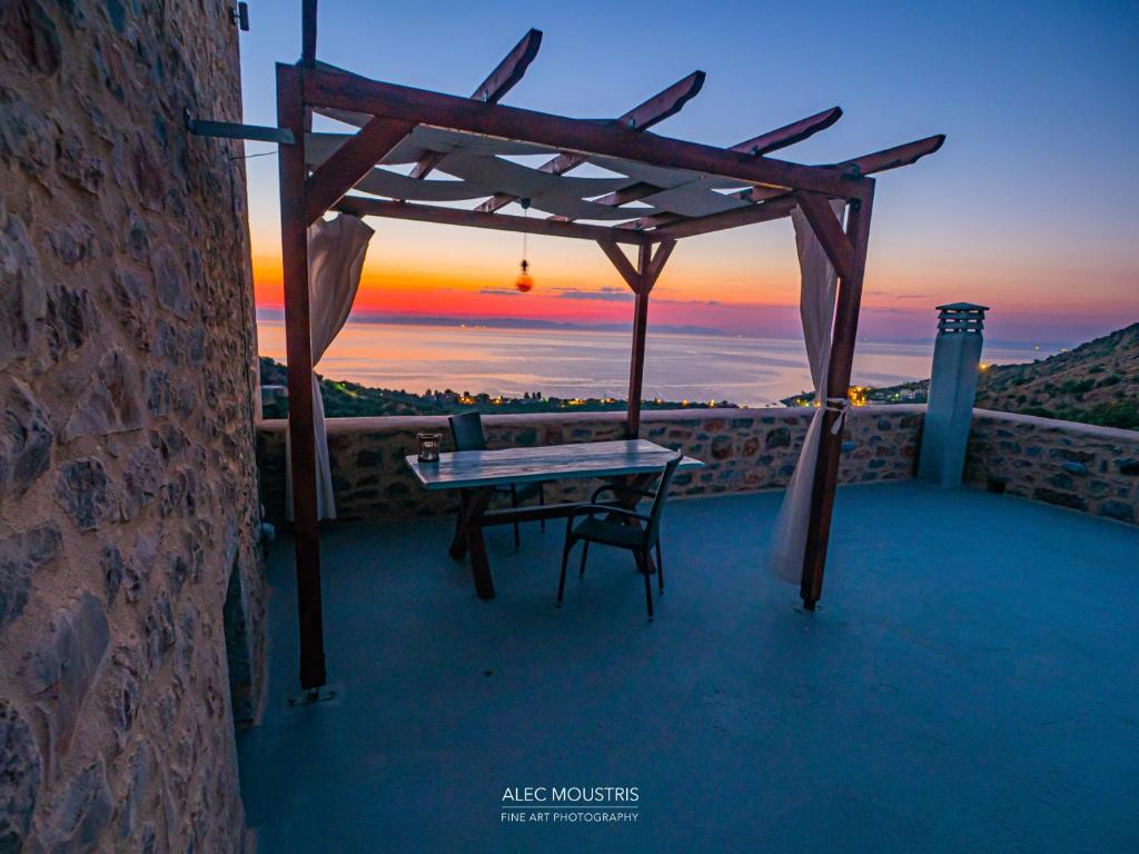 a table and chair on a balcony with the sunset at Soloterra tower in Kokkala