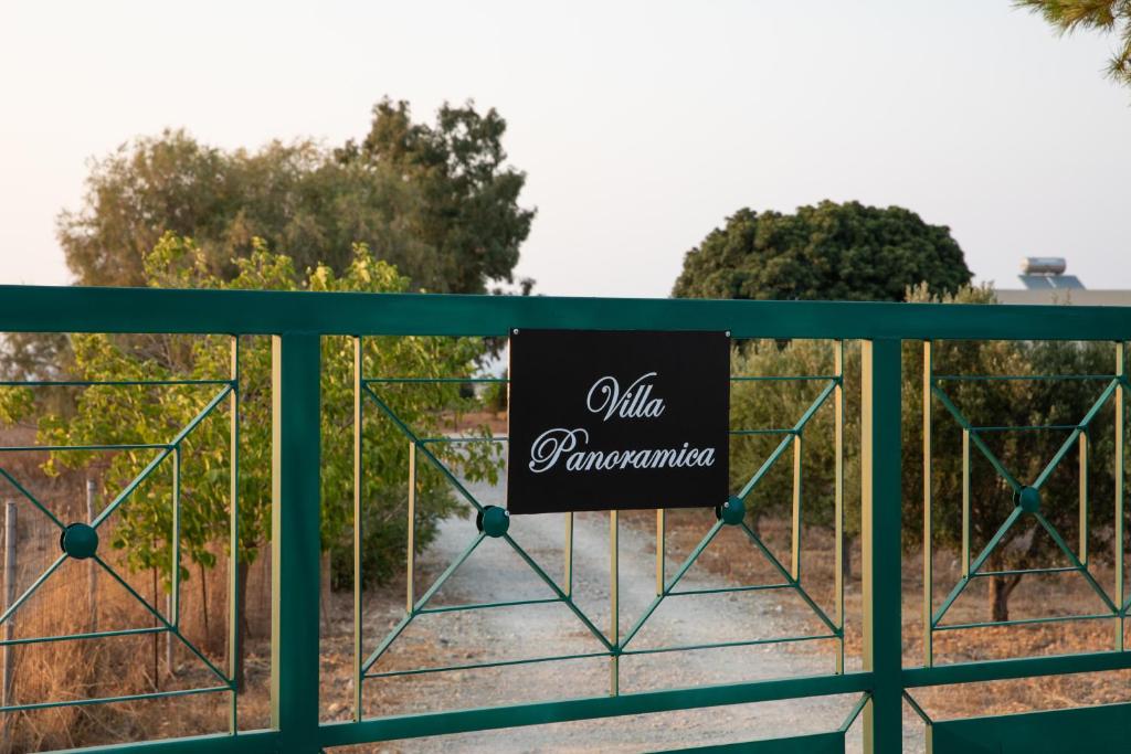 a sign on a fence in front of a park at Villa Panoramica in Pylíon
