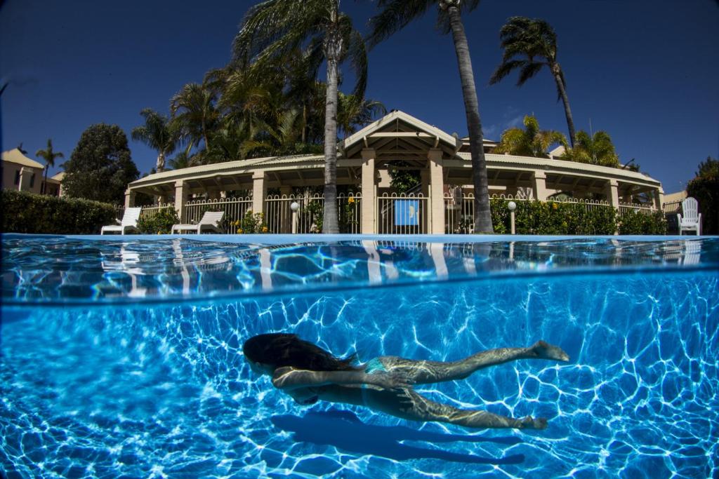 a woman swimming in a swimming pool at Murchison View Apartments in Kalbarri