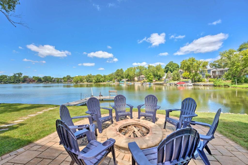 a group of chairs sitting around a fire pit by a lake at Lakefront Oasis with Boat Dock, Fire Pit, Grill in Bristol