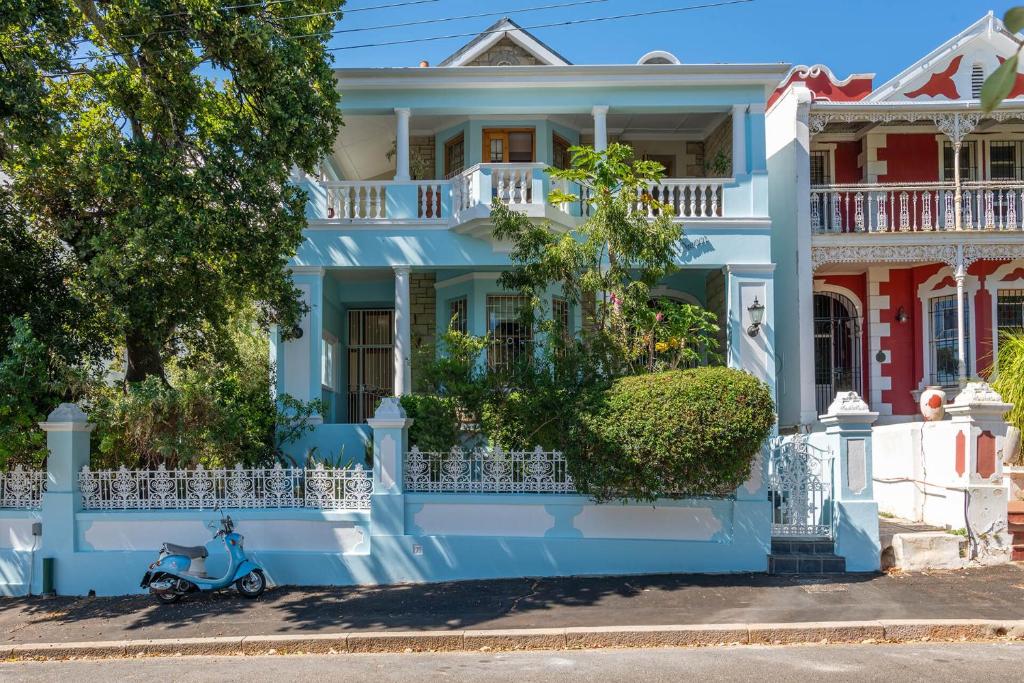 una casa azul con una moto estacionada frente a ella en Villa Bianca B & B, en Ciudad del Cabo