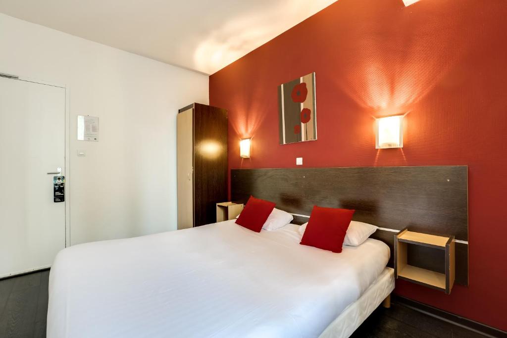 ナルボンヌにあるHôtel Du Midiのベッドルーム1室(赤い壁の白い大型ベッド1台付)