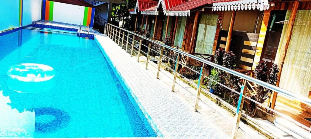 a large blue swimming pool next to a building at white coral beach resort in Havelock Island